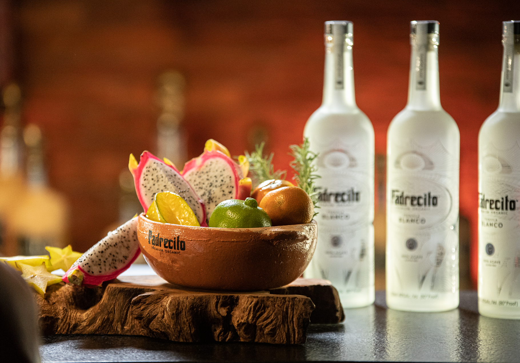Padrecito bottle with a clay bowl of tropical fruit