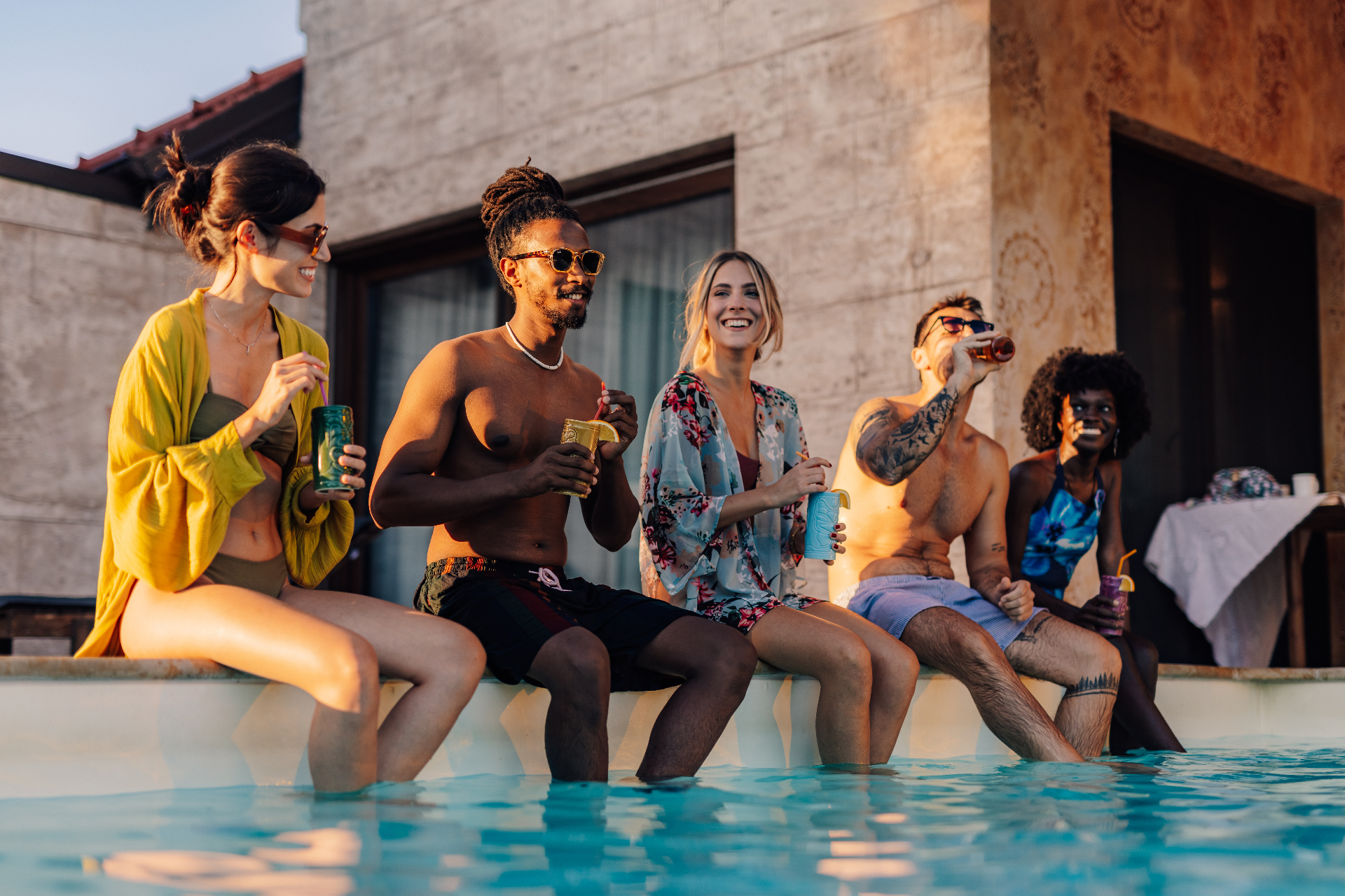 Friends gathered poolside with cocktails in hand