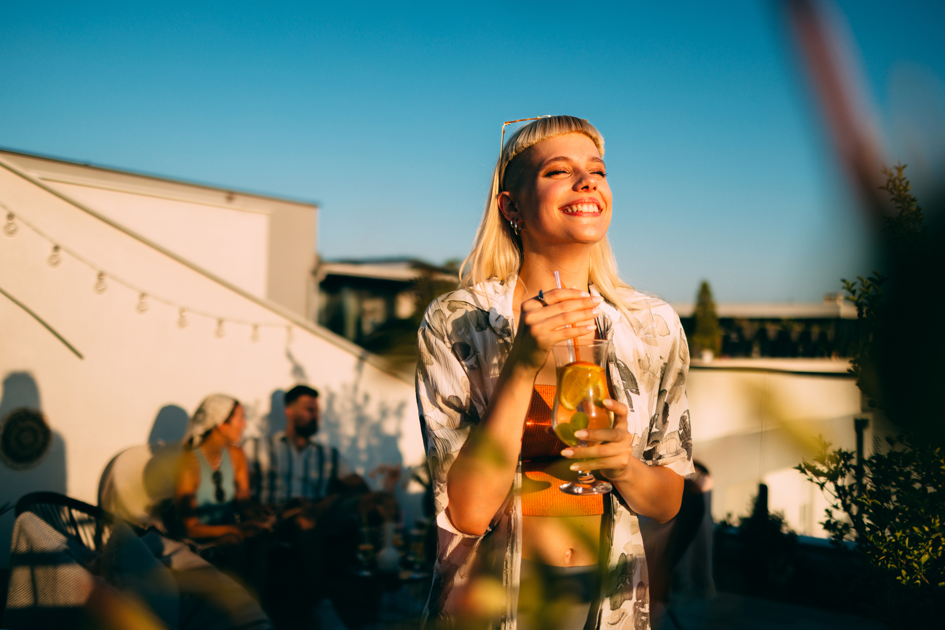 A woman at golden hour with a fresh citrus cocktail