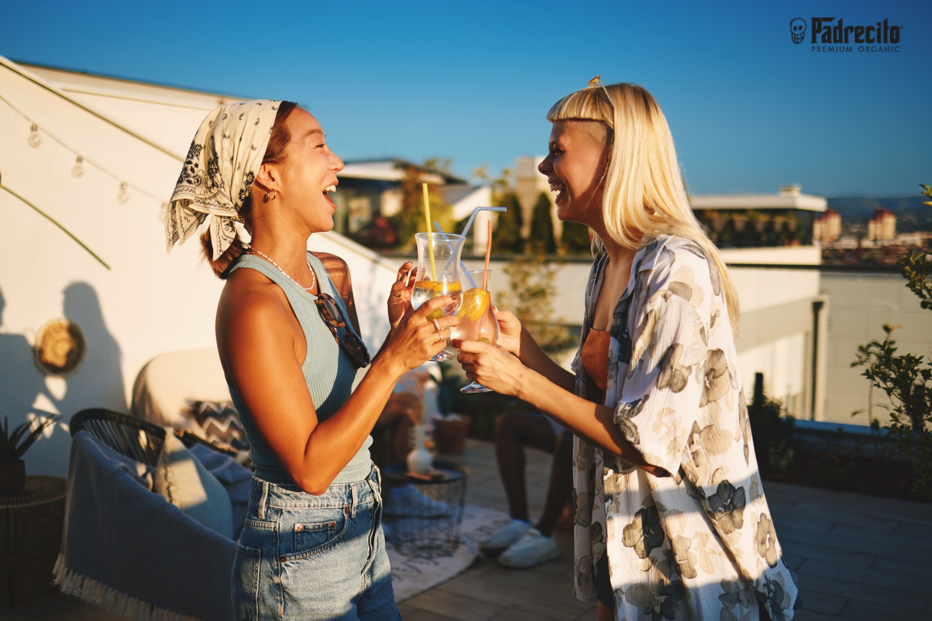 Friends toasting Padrecito cocktails at sunset
